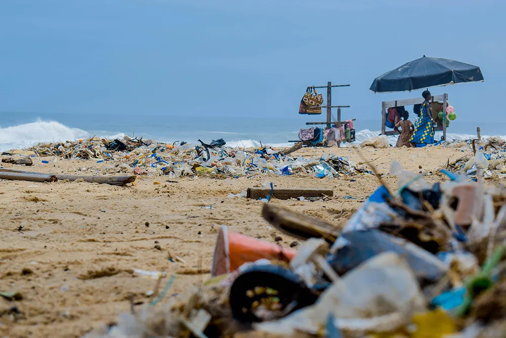 turismo-contaminante Playa contaminada con una gran cantidad de residuos plásticos, mostrando el impacto ambiental negativo del turismo descontrolado y los plásticos de un solo uso.